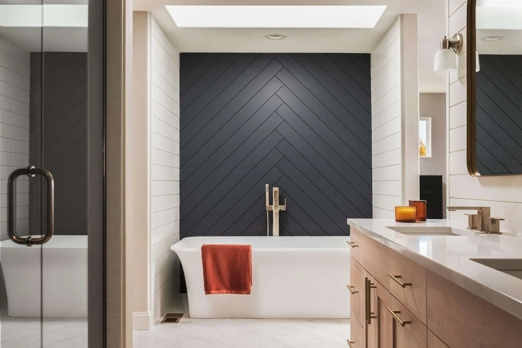 Award winning bathroom remodel with a freestanding tub and dark chevron paneling
